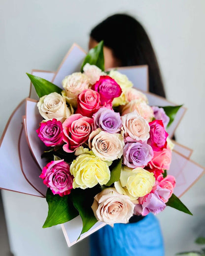 A bouquet of mixed roses featuring a variety of colors such as pink, purple, red, and beige.